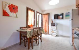 a kitchen with a table and chairs and a refrigerator at Secca 3 in Costa Rei +17 photos
