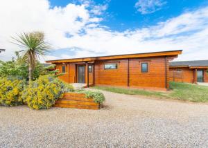 ein Holzhaus mit Gartenanlagen davor in der Unterkunft Fairview Lodges in Withernsea