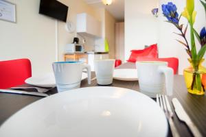 una mesa con un plato blanco y utensilios en ella en Midtown Hotel Triple Room, en Ámsterdam