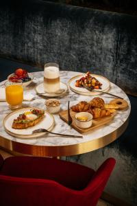 a table with plates of food and drinks on it at Casa de las Artes, member of Meliá Collection in Madrid