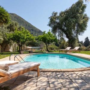 a swimming pool with a bench next to a mountain at The OliveStone Village - Yoga Retreat Paradise in Ágios Márkos