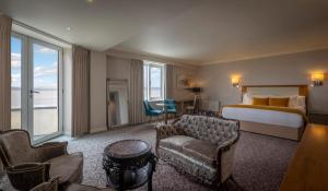 Salthill Hotel في غالواي: غرفه فندقيه بسرير واريكه