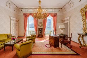 Grand Hotel Villa Serbelloni - A Legendary Hotel في بيلاجيو: غرفة معيشة فيها ثريا وطاولة