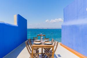 une table avec des chaises et l'océan en arrière-plan dans l'établissement CASA UMI - Magnifique appartement avec accès privé à la mer et grande terrasse, à Marseille