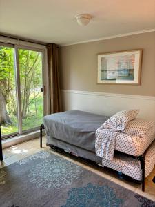 1 dormitorio con 1 cama, 1 silla y 1 ventana en Westhampton Seabreeze Motel, en Westhampton