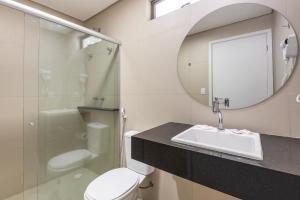 a bathroom with a sink and a toilet and a mirror at NovoHotell Recife in Recife