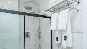 a bathroom with a shower with white towels at Lavender Airport Hotel in Arnavutköy +54 photos