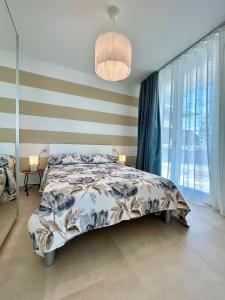 een slaapkamer met een bed en een groot raam bij Golden hour retreat lagoon view villa with pool in Palazzo Vianello