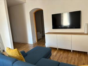 a living room with a blue couch and a flat screen tv at Amas Apartment in Fondi