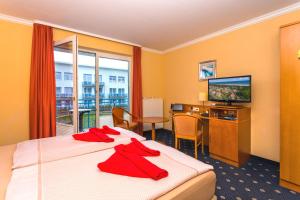 a hotel room with a bed and a television at Hotel & Restaurant Hanse Kogge in Ostseebad Koserow