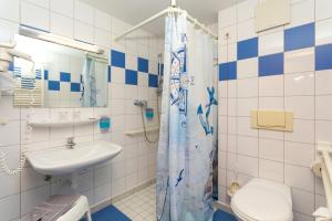 een badkamer met een wastafel, een toilet en een douche bij Hotel & Restaurant Hanse Kogge in Ostseebad Koserow