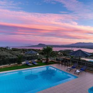 a pool on the roof of a house with a sunset at Villa Roula 3BR Seaview Villa in Chania in Stérnai
