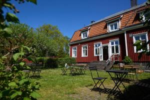 una casa rossa con tavoli e sedie di fronte di Blankaholmsgastgiveri a Blankaholm