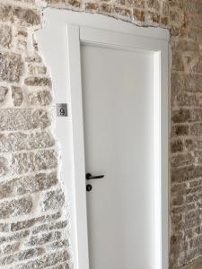 a white door in a brick wall at Centrum Luxury Rooms in Šibenik