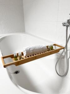 a bathtub with a wooden shelf on the side at Centrum Luxury Rooms in Šibenik