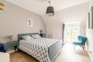 1 dormitorio con 1 cama y 1 silla azul en randonnées à Sert en La Chapelle-de-Brain