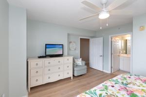 1 dormitorio con cama y vestidor con TV en Destin West Sandpiper Bld 501 Bay side Condo en Fort Walton Beach