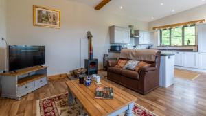 a living room with a couch and a table at Old Stables, Little Ballthorns Farm in Cold Ashton