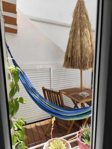 una hamaca y una mesa en una habitación en Stressfree Apartamento, en Vila Nova de Milfontes