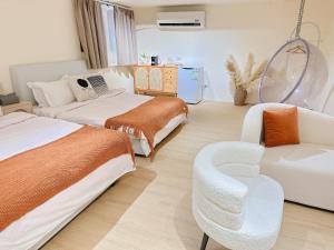 una camera da letto con due letti, una poltrona e un divano di Homiday a Puli