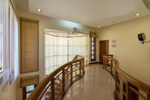 a hallway with wooden stairs and a large window at StayVista at PleasantVille with Huge Lawn Area in Nāhan