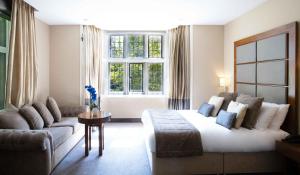 a bedroom with a bed and a couch and a window at Wellington Hotel by Blue Orchid in London
