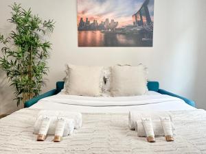 ein Bett mit weißer Bettwäsche und Handtüchern darauf in der Unterkunft 1601 - Charming studio in Paris Olympic Games 2024 in Paris