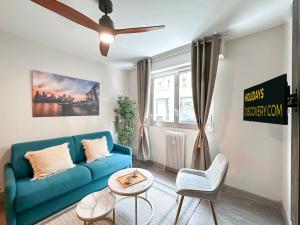 ein Wohnzimmer mit einem blauen Sofa und einem Tisch in der Unterkunft 1601 - Charming studio in Paris Olympic Games 2024 in Paris