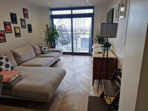 a living room with a couch and a table at Cosy 1 bedroom apartment with balcony near Chiswick in London