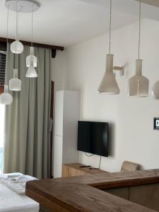 sala de estar con TV y luces colgantes en Apartments Lungo Mare, en Sveti Stefan