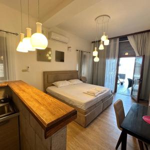 a bedroom with a bed and a kitchen with lights at Apartments Lungo Mare in Sveti Stefan
