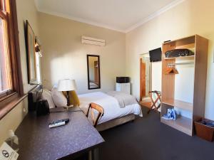 a hotel room with a bed and a desk at Cummings Guesthouse in Wellington