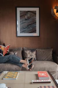 a person laying on a couch reading a book at Lodge Park in Meg&egrave;ve