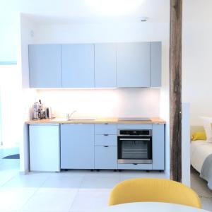 eine Küche mit weißen Schränken und einem gelben Stuhl in der Unterkunft Auterive-Évasions-Échapée-parking gratuit, hypercentre, gare in Auterive