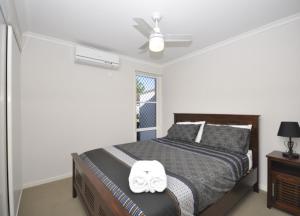 a bedroom with a bed and a ceiling fan at Capricorn Villas in Middlemount