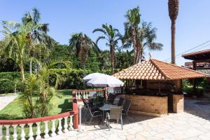 einen Pavillon mit einem Tisch, Stühlen und Palmen in der Unterkunft San Benito - spektakuläres Haus mit Privatpool für bis zu 13 Gäste in Los Realejos