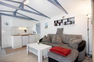 una sala de estar con un sofá y una mesa en Bungalow Netzboden, Bgl 28, en Dranske