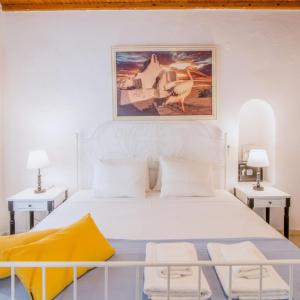 ミコノス・シティにあるLike a white seagull in Mykonos!の白いベッドルーム(大きな白いベッド1台、テーブル2台付)