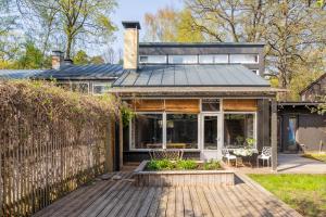 a home with a wooden deck and a fence at Family private house in Dubulti, Jurmala, 400m to the beach in Jūrmala