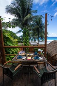 - une table sur une terrasse avec vue sur la plage dans l'établissement Casa Conceição, à Fernando de Noronha