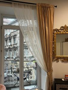 - une fenêtre avec des rideaux et une vue sur un bâtiment dans l'établissement Apartment Cont, à Rijeka