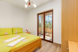 a bedroom with a bed and a sliding glass door at Irena&Dolores Apartments in Malinska