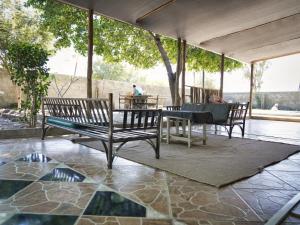 un patio con 2 panche, un tavolo e un tavolo con sedie di Golentle Home Stay a Maun