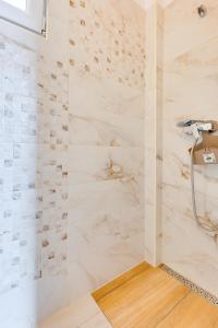 a bathroom with a shower with white marble walls at Irena&Dolores Apartments in Malinska