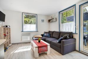 una sala de estar con un sofá y una mesa en Bungalow Mary Ann, Bgl 25, en Dranske