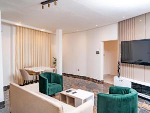 a living room with a couch and chairs and a table at Appartement Bali (Asie) in Cotonou