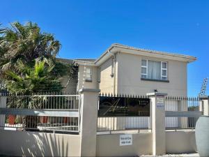 a house with a fence and a palm tree at Amani Luxe Villa in Amsterdamhoek