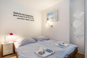 Un pequeño dormitorio con una cama con toallas. en Bungalow 'zur Möwe' - Bgl 22, en Dranske