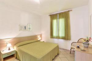 a bedroom with a green bed and a window at Casa Ilva - Colle Paradiso Experience in Capoliveri