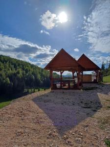 un refugio de picnic de madera con el sol en el cielo en Pensiunea Poarta Lui Ionele, en Gârda de Sus